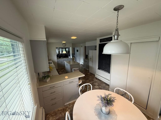2821 Edwards, Butte, MT 59701 - kitchen featuring gray cabinetry, white fridge with ice dispenser, healthy amount of natural light, and a center island