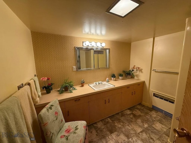 2821 Edwards, Butte, MT 59701 - bathroom featuring radiator heating unit, vanity, and stone finish floors
