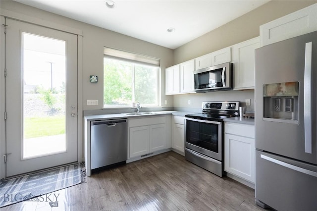 4454 Shadow Gln, Bozeman, MT 59718 - kitchen with stainless steel appliances, white cabinets, wood finished floors, light countertops, and recessed lighting