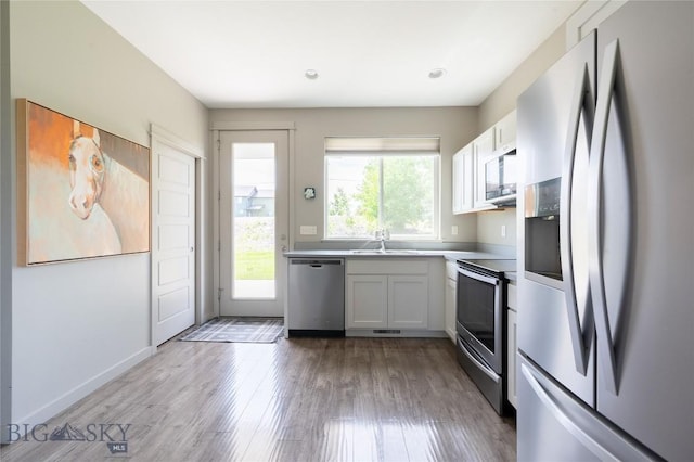 4454 Shadow Gln, Bozeman, MT 59718 - kitchen featuring stainless steel appliances, wood finished floors, recessed lighting, and white cabinets