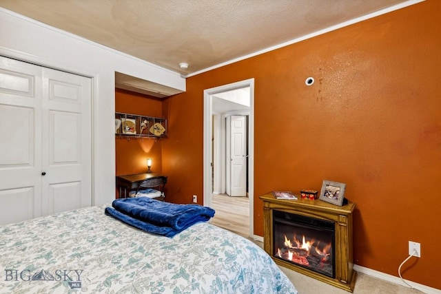 2801 W Villard St, Bozeman, MT 59718 - bedroom featuring a glass covered fireplace, a closet, and crown molding