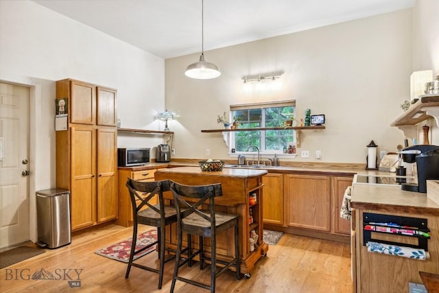 2801 W Villard St, Bozeman, MT 59718 - kitchen featuring open shelves, light wood-style floors, a kitchen island, and brown cabinetry