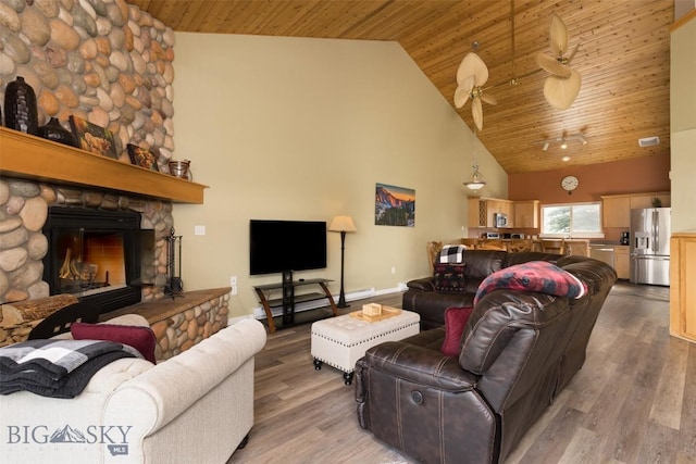 456 Firelight, Big Sky, MT 59716 - living room with high vaulted ceiling, wood ceiling, light wood-style flooring, a stone fireplace, and a ceiling fan