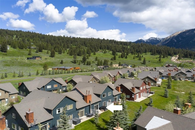 456 Firelight, Big Sky, MT 59716 - aerial perspective of suburban area with a heavily wooded area and a mountain backdrop