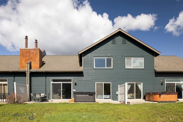 456 Firelight, Big Sky, MT 59716 - back of house featuring a hot tub, roof with shingles, and a yard