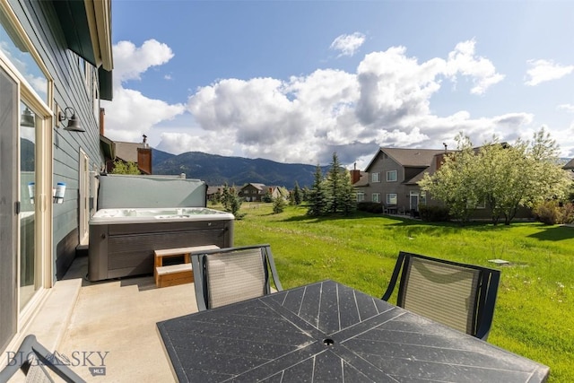 456 Firelight, Big Sky, MT 59716 - view of patio / terrace featuring a hot tub, outdoor dining area, and a mountain view
