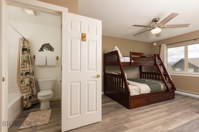 456 Firelight, Big Sky, MT 59716 - bedroom with wood finished floors, a baseboard radiator, ensuite bathroom, and ceiling fan