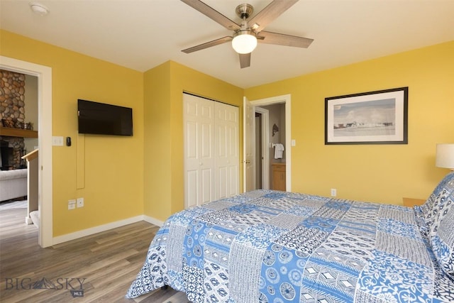 456 Firelight, Big Sky, MT 59716 - bedroom with wood finished floors, a closet, ceiling fan, and a fireplace