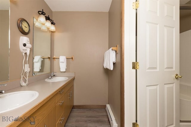 456 Firelight, Big Sky, MT 59716 - full bathroom with a baseboard heating unit, double vanity, and wood finished floors