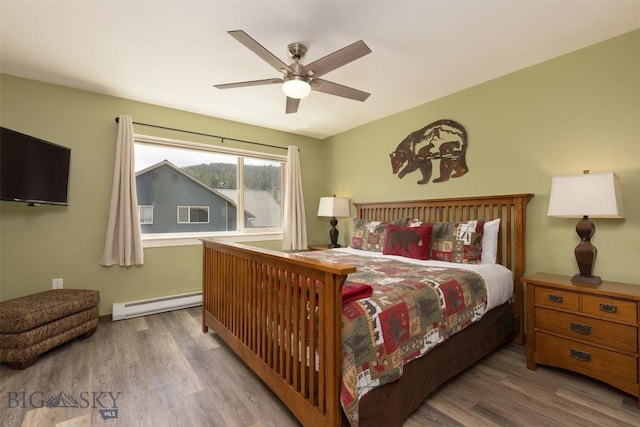 456 Firelight, Big Sky, MT 59716 - bedroom with baseboard heating, wood finished floors, and ceiling fan