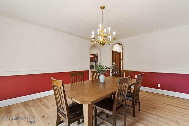 10423 Bridger Canyon Rd, Bozeman, MT 59715 - dining area featuring arched walkways, wood finished floors, a chandelier, and ornamental molding