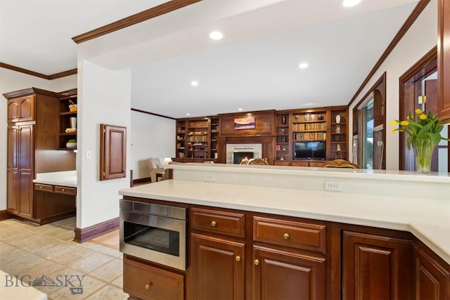 10423 Bridger Canyon Rd, Bozeman, MT 59715 - kitchen featuring stainless steel microwave, light countertops, crown molding, built in shelves, and open floor plan