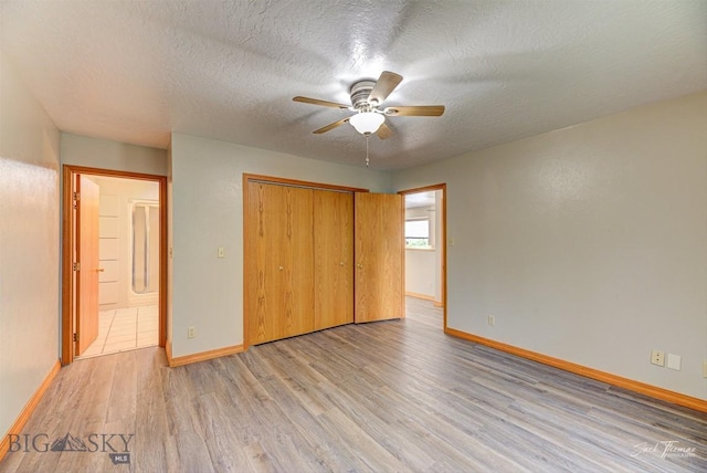 620 Higgins, Deer Lodge, MT 59722 - unfurnished bedroom with light wood-style floors, a closet, a textured ceiling, and ceiling fan