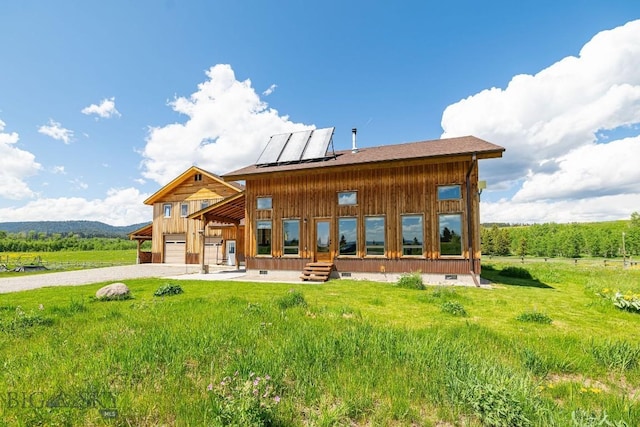 241 Aspen Loop Rd, West Yellowstone, MT 59758 - rear view of house with an attached garage, gravel driveway, crawl space, solar panels, and board and batten siding
