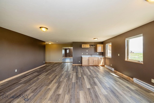 241 Aspen Loop Rd, West Yellowstone, MT 59758 - unfurnished living room featuring baseboard heating and dark wood finished floors