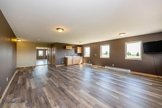 241 Aspen Loop Rd, West Yellowstone, MT 59758 - unfurnished living room with a baseboard heating unit, dark wood-style flooring, and wet bar