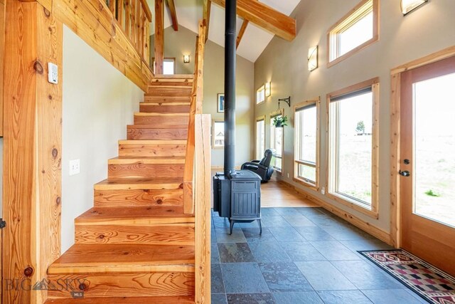 241 Aspen Loop Rd, West Yellowstone, MT 59758 - stairway with a wood stove, healthy amount of natural light, beamed ceiling, and high vaulted ceiling