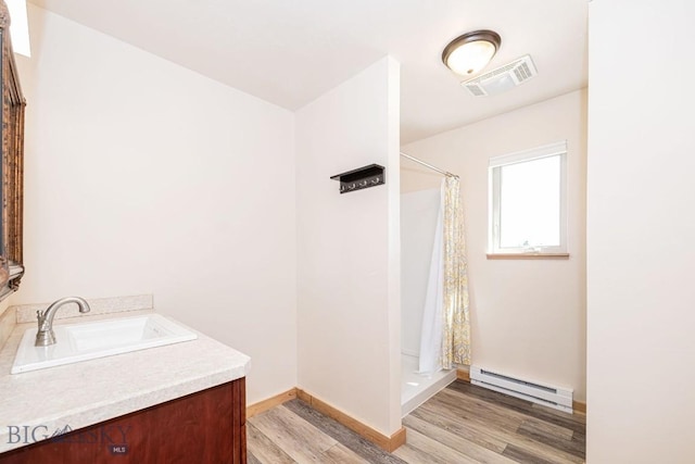 241 Aspen Loop Rd, West Yellowstone, MT 59758 - full bathroom with a baseboard radiator, wood finished floors, vanity, and a shower with shower curtain