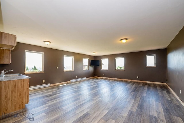 241 Aspen Loop Rd, West Yellowstone, MT 59758 - unfurnished living room with baseboard heating and dark wood-style floors