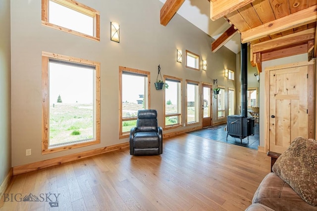 241 Aspen Loop Rd, West Yellowstone, MT 59758 - living area featuring beamed ceiling, a wood stove, high vaulted ceiling, and hardwood / wood-style flooring