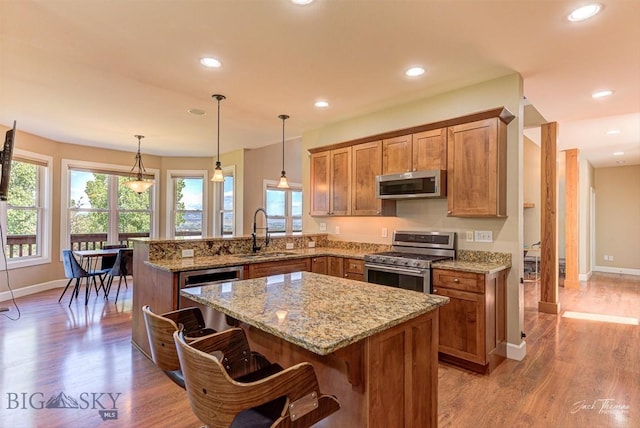 960 Strawberry, Helena, MT 59601 - kitchen with stainless steel appliances, brown cabinetry, light wood-type flooring, a peninsula, and recessed lighting