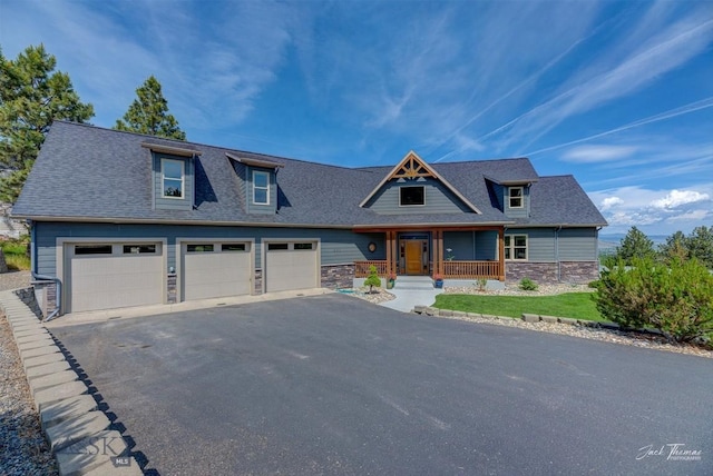 960 Strawberry, Helena, MT 59601 - view of front of house featuring a porch, stone siding, driveway, roof with shingles, and a garage
