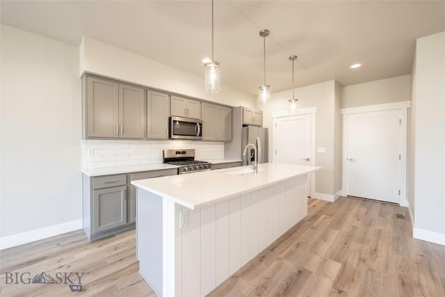 488 Meriwether Ave, Bozeman, MT 59718 - kitchen with appliances with stainless steel finishes, gray cabinets, decorative backsplash, light countertops, and light wood-type flooring