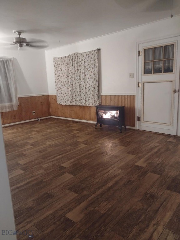 600 C St, Townsend, MT 59644 - unfurnished living room featuring wainscoting, wood finished floors, a ceiling fan, and wooden walls