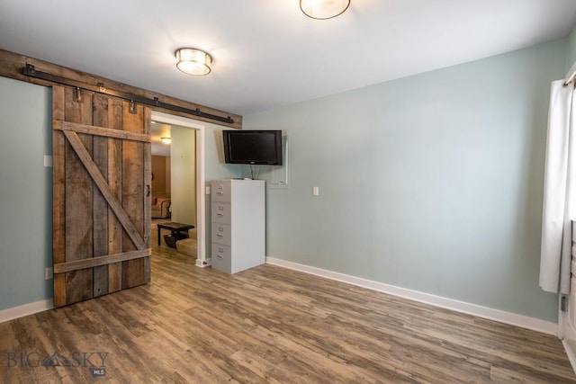 605 E Cameron Brg, Bozeman, MT 59718 - unfurnished living room with a barn door and wood finished floors