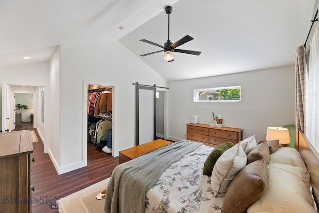 25 W Dooley Ln, Belgrade, MT 59714 - bedroom featuring a barn door, a walk in closet, vaulted ceiling, dark wood-type flooring, and a closet