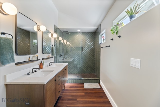 25 W Dooley Ln, Belgrade, MT 59714 - bathroom featuring double vanity, wood finished floors, vaulted ceiling, and a walk in shower