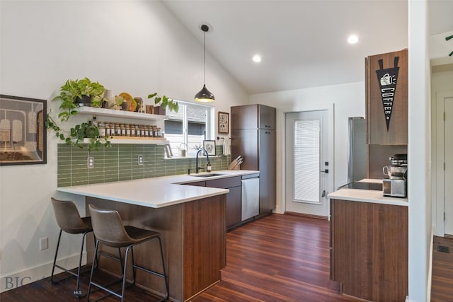 25 W Dooley Ln, Belgrade, MT 59714 - kitchen with a peninsula, dishwasher, dark wood-type flooring, a kitchen bar, and light countertops