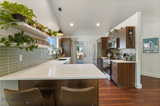 25 W Dooley Ln, Belgrade, MT 59714 - kitchen featuring appliances with stainless steel finishes, open shelves, decorative backsplash, light countertops, and a peninsula