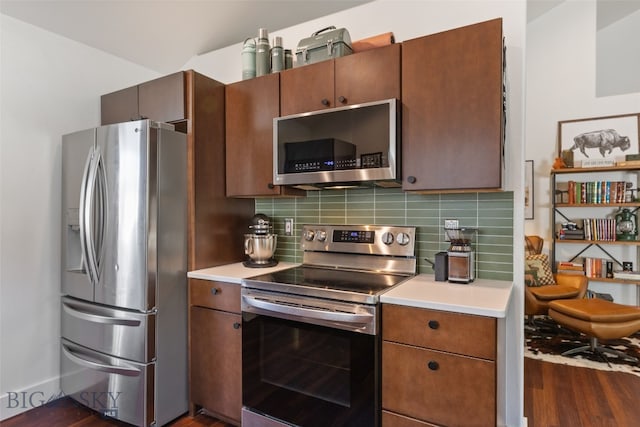 25 W Dooley Ln, Belgrade, MT 59714 - kitchen with stainless steel appliances, dark wood-style floors, tasteful backsplash, and light countertops