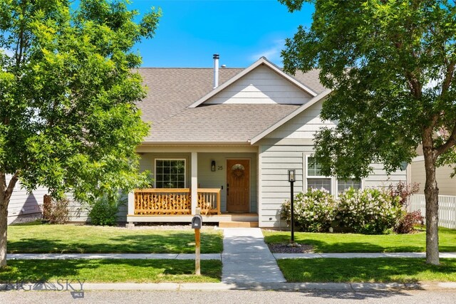 25 W Dooley Ln, Belgrade, MT 59714 - view of front of property featuring a shingled roof, a porch, and a front lawn