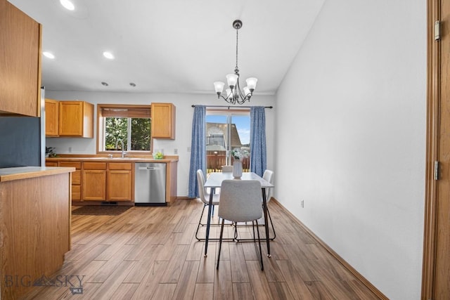 704 Mayfair Dr, Belgrade, MT 59714 - kitchen with dishwasher, a chandelier, light wood-style flooring, light countertops, and pendant lighting
