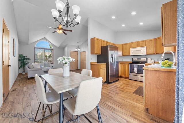704 Mayfair Dr, Belgrade, MT 59714 - kitchen with appliances with stainless steel finishes, vaulted ceiling, light wood-style floors, open floor plan, and recessed lighting
