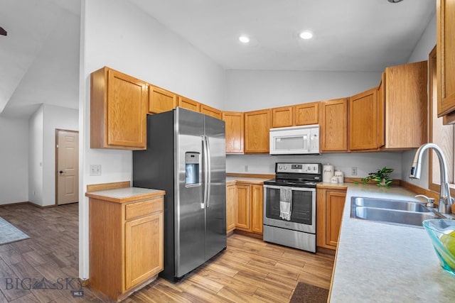 704 Mayfair Dr, Belgrade, MT 59714 - kitchen featuring stainless steel appliances, high vaulted ceiling, light countertops, light wood-style flooring, and recessed lighting