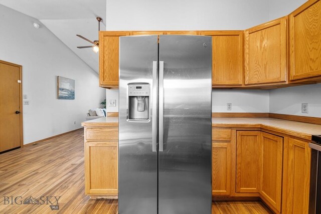 704 Mayfair Dr, Belgrade, MT 59714 - kitchen featuring stainless steel fridge, a ceiling fan, vaulted ceiling, light countertops, and light wood-style floors