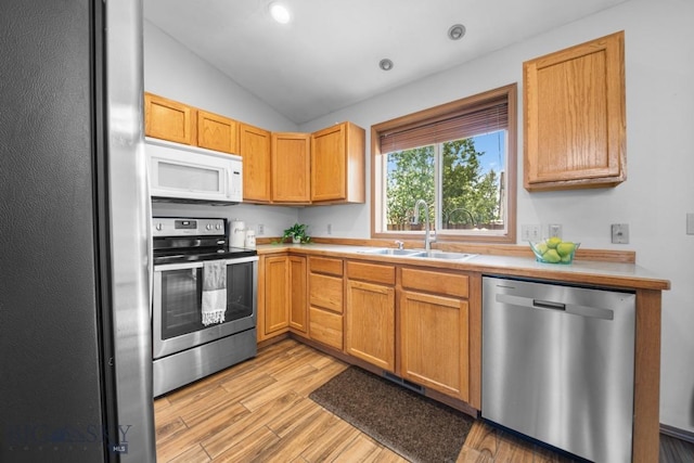 704 Mayfair Dr, Belgrade, MT 59714 - kitchen with appliances with stainless steel finishes, light countertops, light wood-style flooring, vaulted ceiling, and recessed lighting