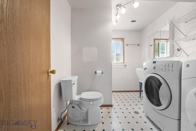 704 Mayfair Dr, Belgrade, MT 59714 - bathroom with plenty of natural light, washing machine and clothes dryer, tile patterned floors, and rail lighting