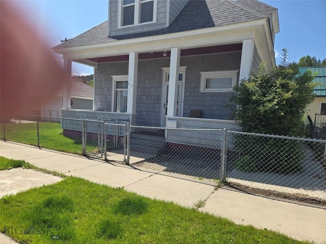 415 W 6th St, Anaconda, MT 59711 - view of front of home featuring covered porch, a fenced front yard, a shingled roof, and a gate