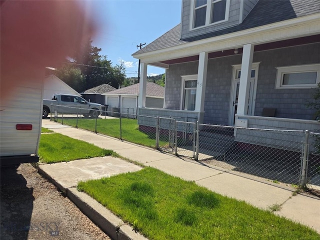 415 W 6th St, Anaconda, MT 59711 - property entrance featuring covered porch, a gate, a shingled roof, and a detached garage