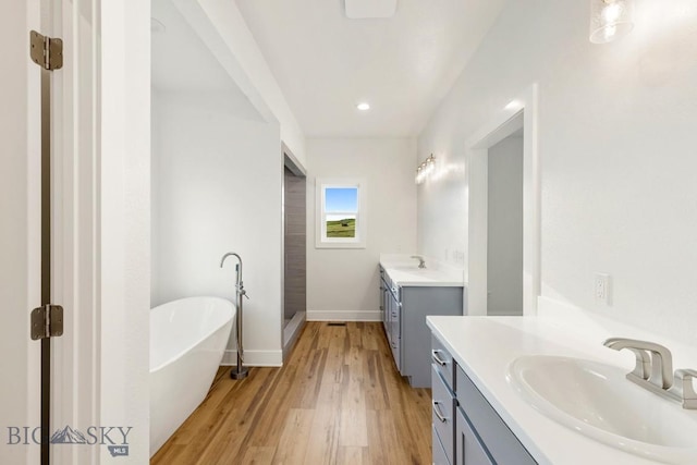 20 Hollow Top Trl, Three Forks, MT 59752 - bathroom with two vanities, a freestanding tub, wood finished floors, and recessed lighting