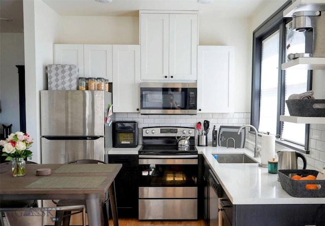 101 W Quartz Unit 1A, Butte, MT 59701 - kitchen with stainless steel appliances, light countertops, white cabinetry, and decorative backsplash