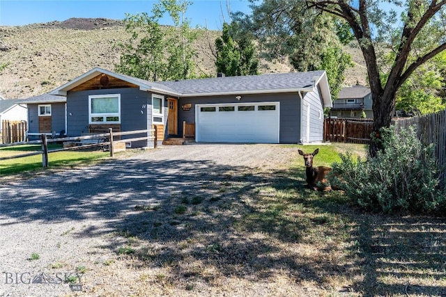 14 Peters Ln, Gardiner, MT 59030 - ranch-style home with gravel driveway, an attached garage, and a mountain view