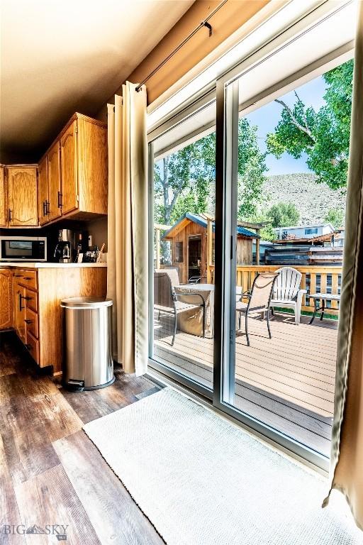 14 Peters Ln, Gardiner, MT 59030 - kitchen featuring stainless steel microwave, dark wood-type flooring, brown cabinetry, and light countertops