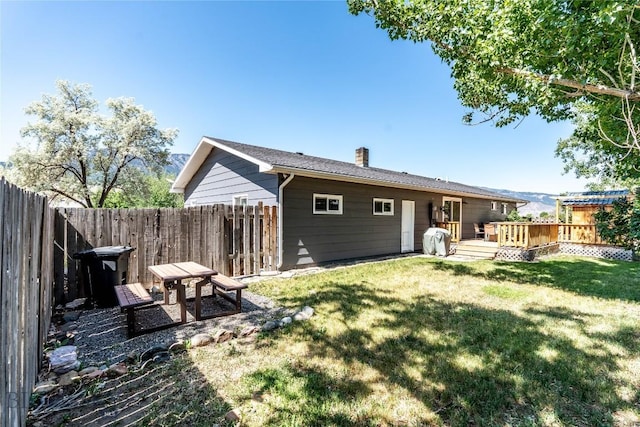 14 Peters Ln, Gardiner, MT 59030 - rear view of house featuring a fenced backyard, a deck, and a chimney