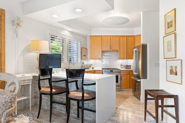 1037 Boylan Rd Unit 1, Bozeman, MT 59715 - kitchen featuring appliances with stainless steel finishes, a kitchen breakfast bar, decorative backsplash, light countertops, and recessed lighting