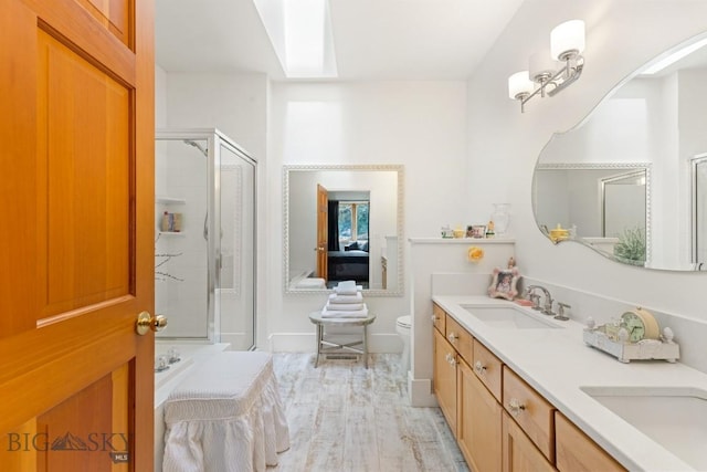 1037 Boylan Rd Unit 1, Bozeman, MT 59715 - full bathroom featuring a stall shower, double vanity, a skylight, and wood finished floors